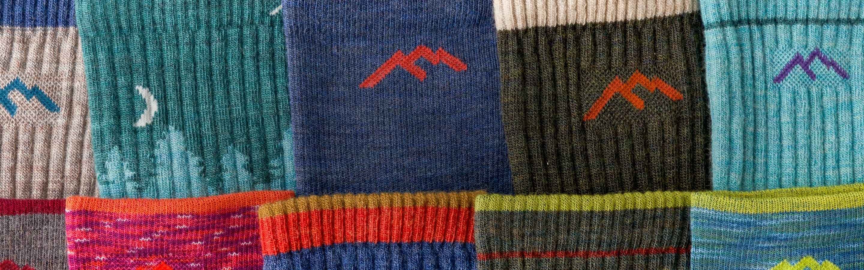 A closeup of a bunch of Darn Tough socks in different colors, all laid out