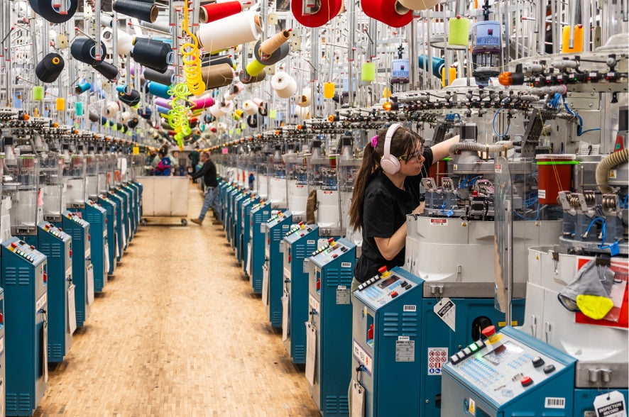 A view down a row of knitting machines at the Darn Tough mill in Vermont, USA