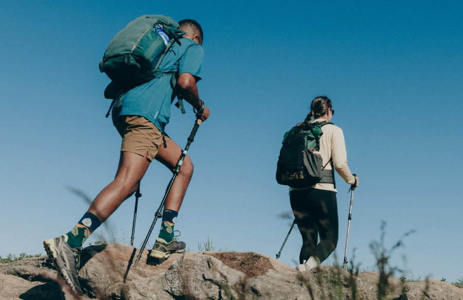 A pair of hikers wearing Darn Tough socks and heading over rocks