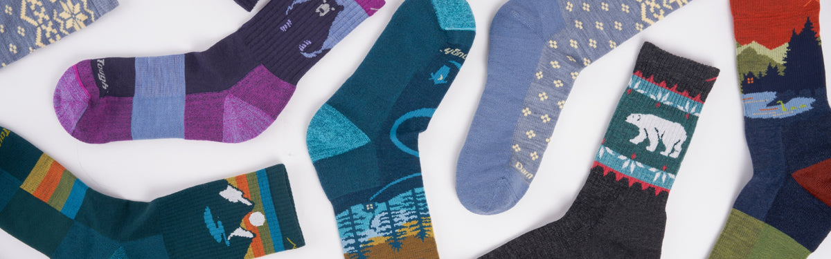 A bunch of Darn Tough hiking socks laid out to show their fun designs
