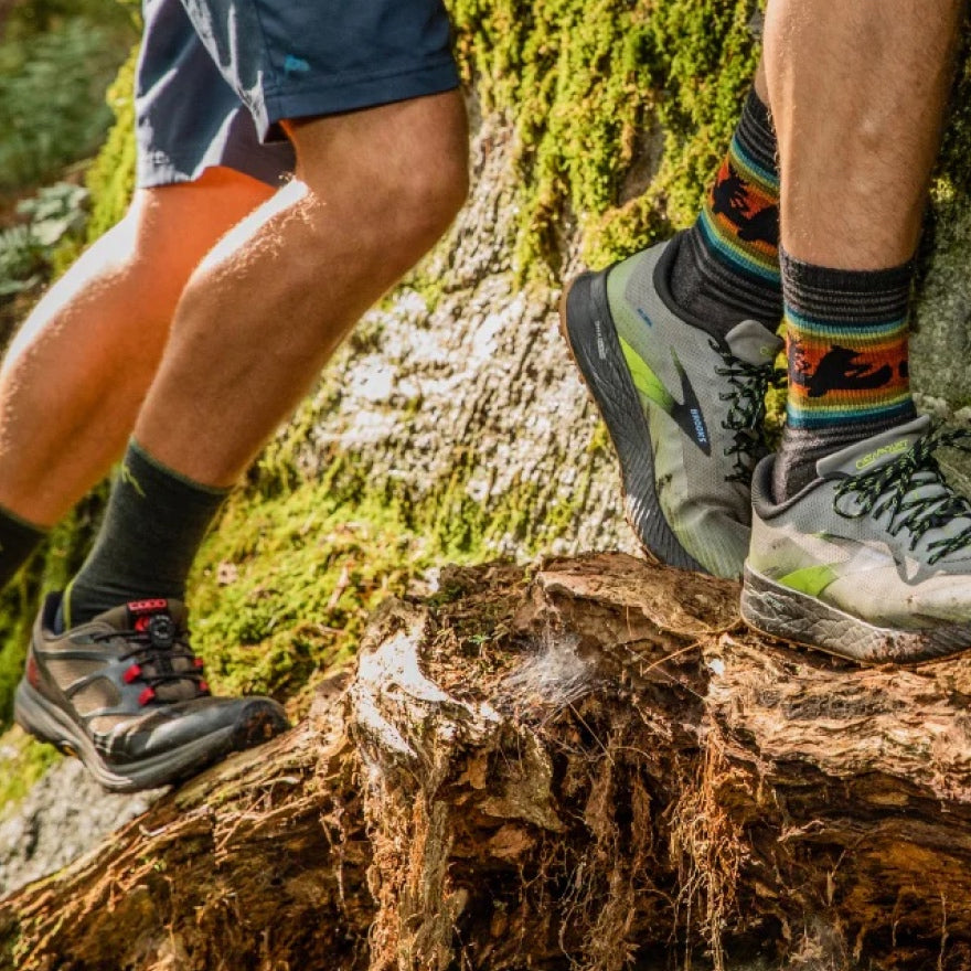 Two hikers headed up a trail, the view on their sock-clad feet