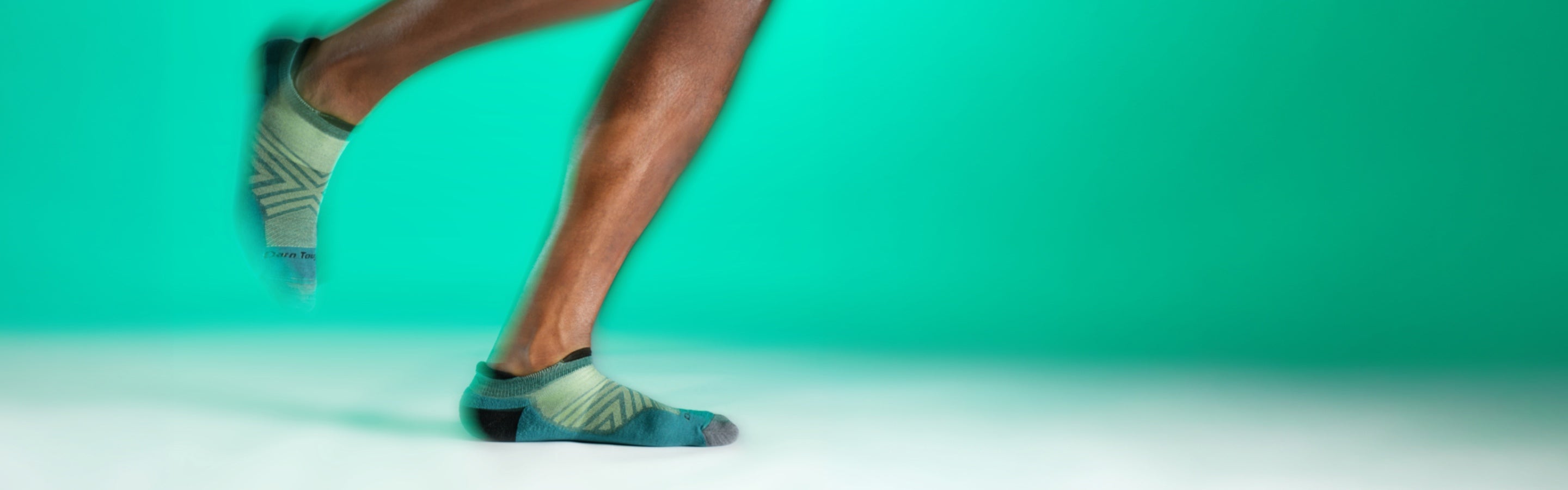 Feet wearing the run no show tab sock and taking a running stride