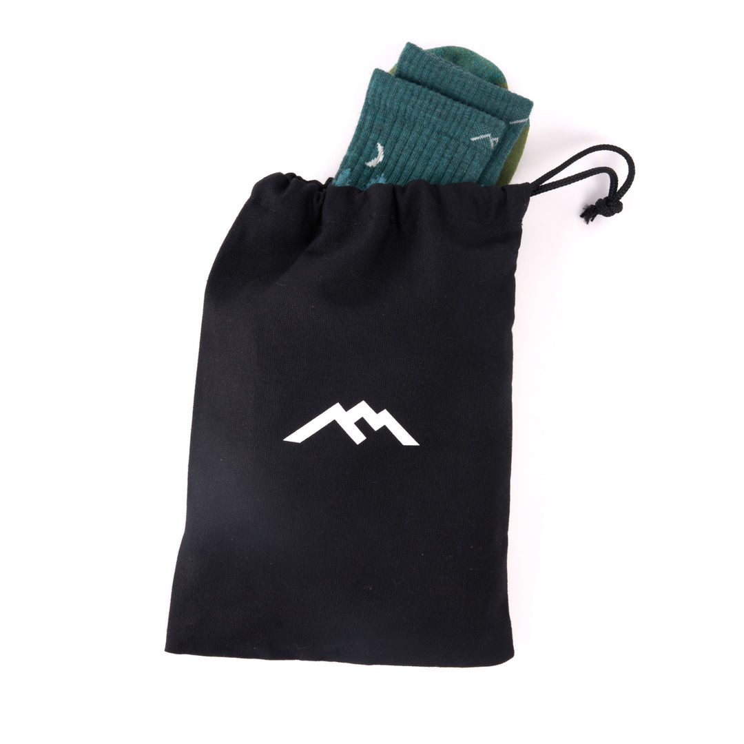 gift bag with sock sticking out on white background black bag with white logo