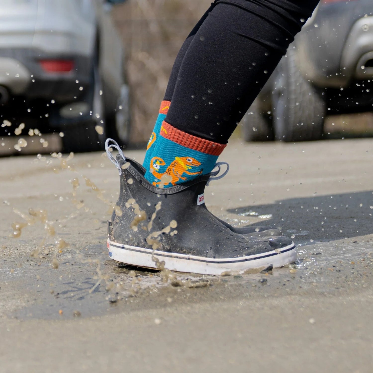 Model wearing the kids sal micro crew hiking socks splashing in a puddle