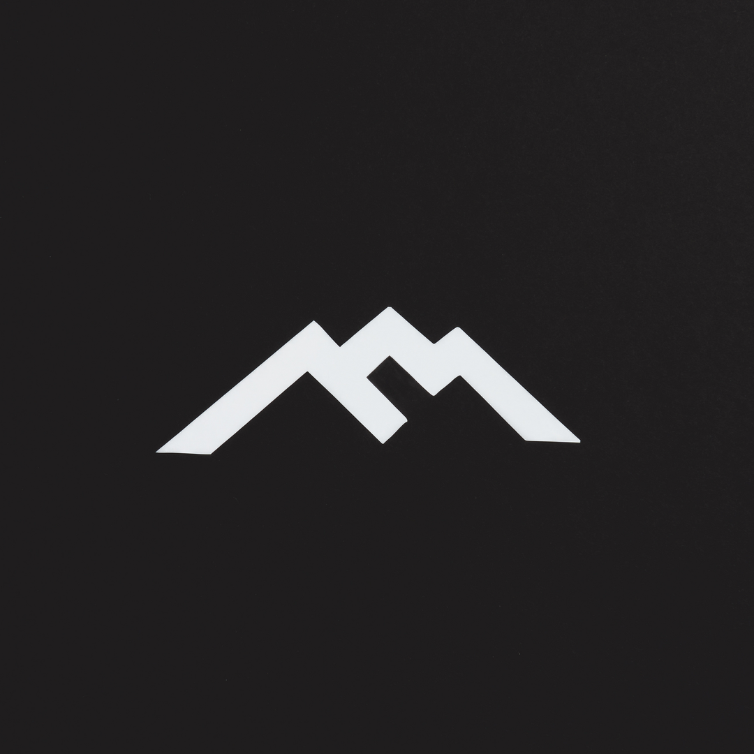 White Darn Tough mountain logo sticker against black background