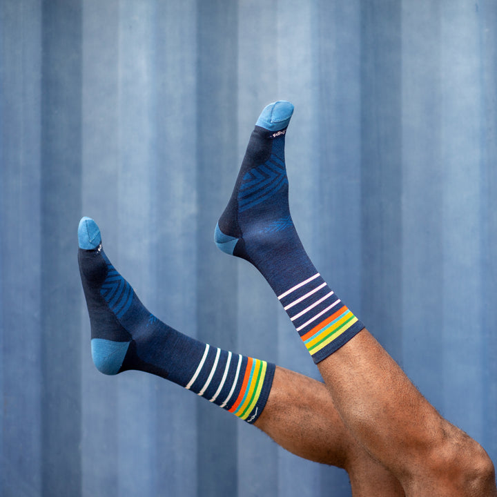 Side shot of model with their feet up in the air wearing the men's stride micro crew running sock in eclipse blue