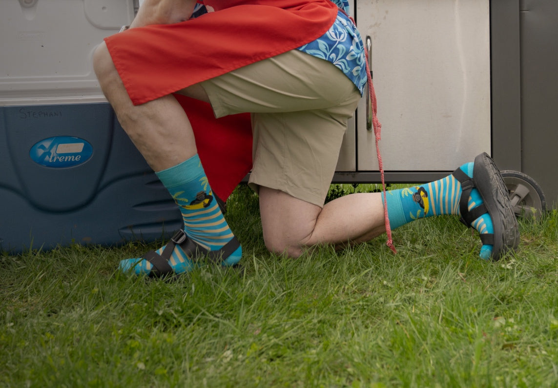 dad grabbing a drink, feet in fun, bright socks with sandals