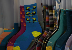 A whole bunch of socks hanging on a rack