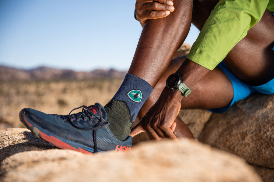 Hiker seated on rock wearing PCT socks