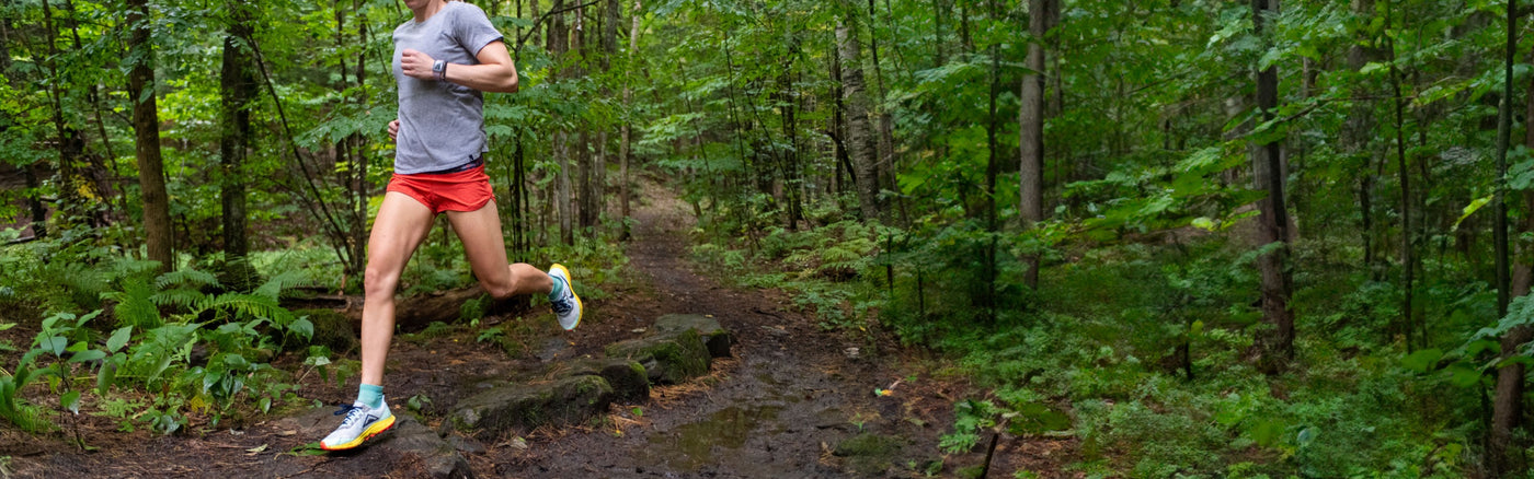 A runner headed down a trail wearing Darn Tough Ultralight Run Quarter Socks