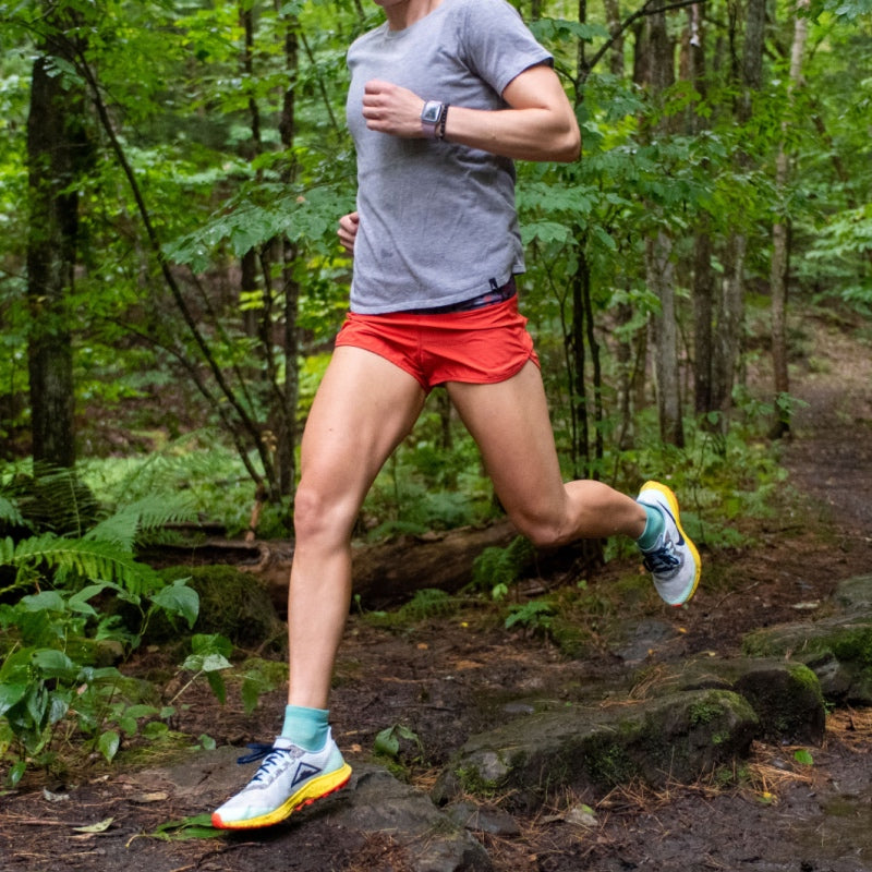 A runner headed down a trail wearing Darn Tough Ultralight Run Quarter Socks