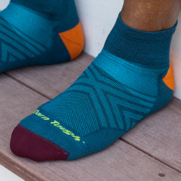 Feet wearing the Run Quarter in blue, showing the mesh venting over the top of the foot