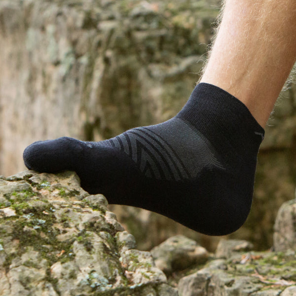 Foot wearing the Run Quarter in black, showing the ultralight cushioning underfoot