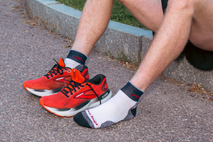 A pair of feet wearing the Throwback Race Day sock, a re-knit of our original Darn Tough run sock