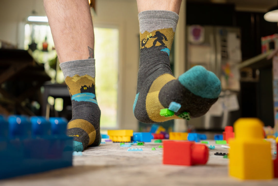 Low angle shot of feet wearing the Close Encounters sock, legos stuck to the bottom