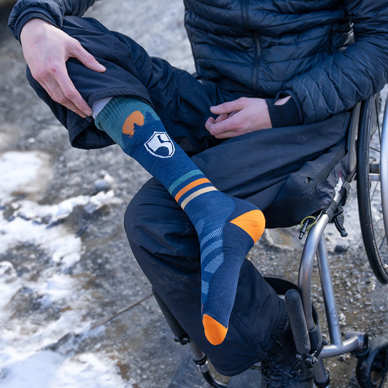 Person seated in wheel chair wearing the High Fives ski socks