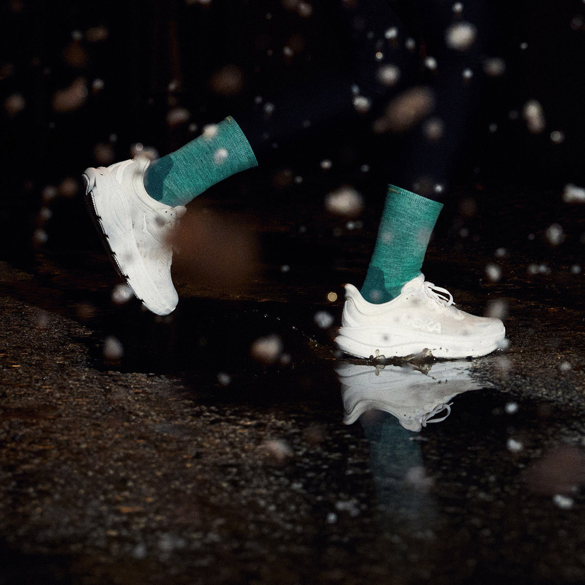 A runner out in the dark wearing the women's run micro crew in teal with white shoes