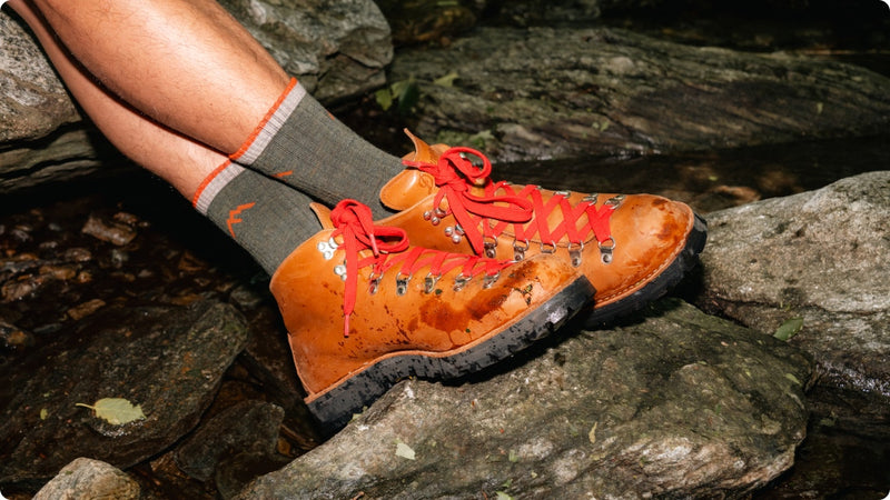 A pair of feet wearing Hiker Micro Crew socks with leather boots
