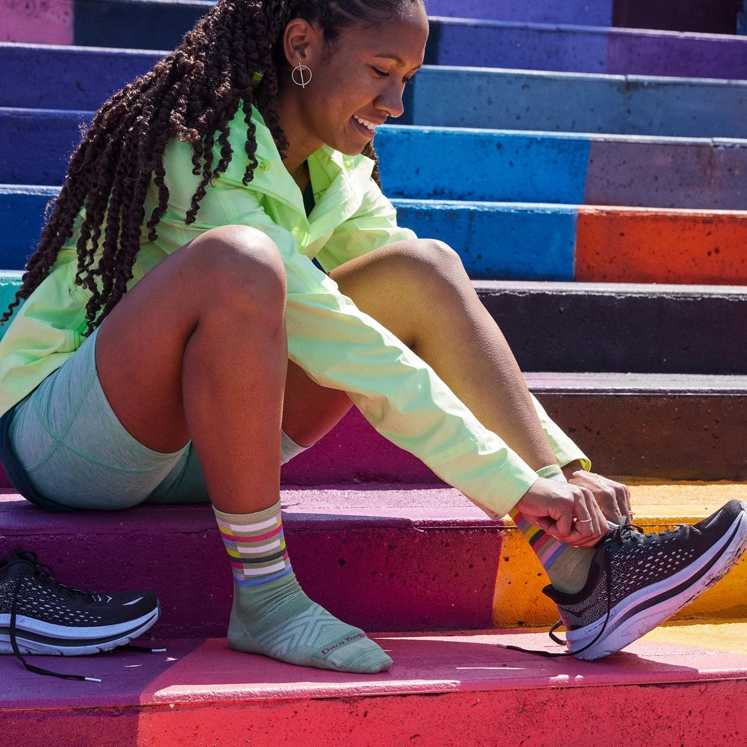 Model tying her run shoes wearing the women's relay micro crew running socks