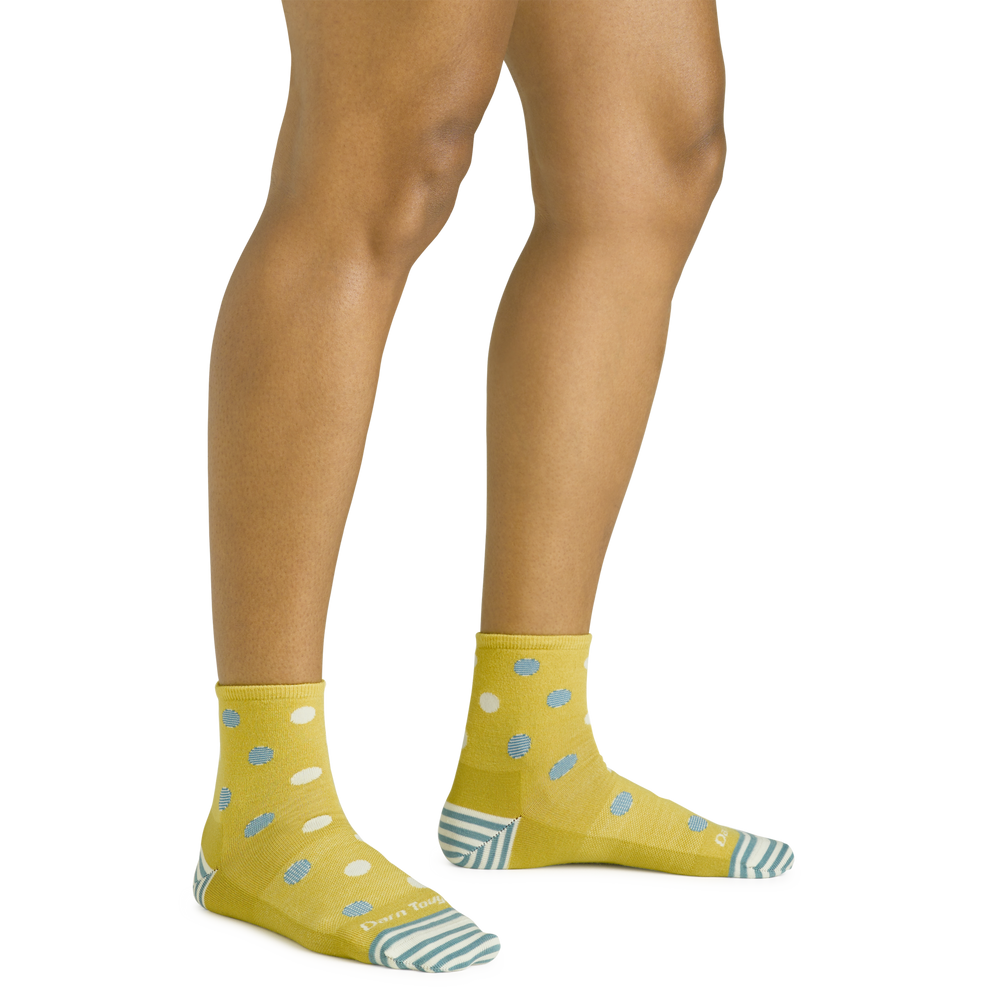 Close up shot of model wearing the women's dottie shorty lifestyle sock in buttercup yellow with no shoes on