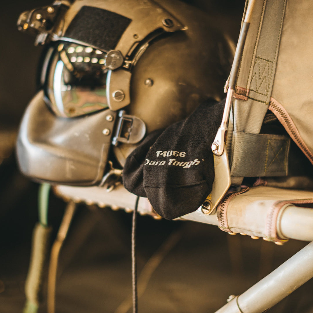 A pair of Darn Tough tactical socks sticking out next to some flight gear