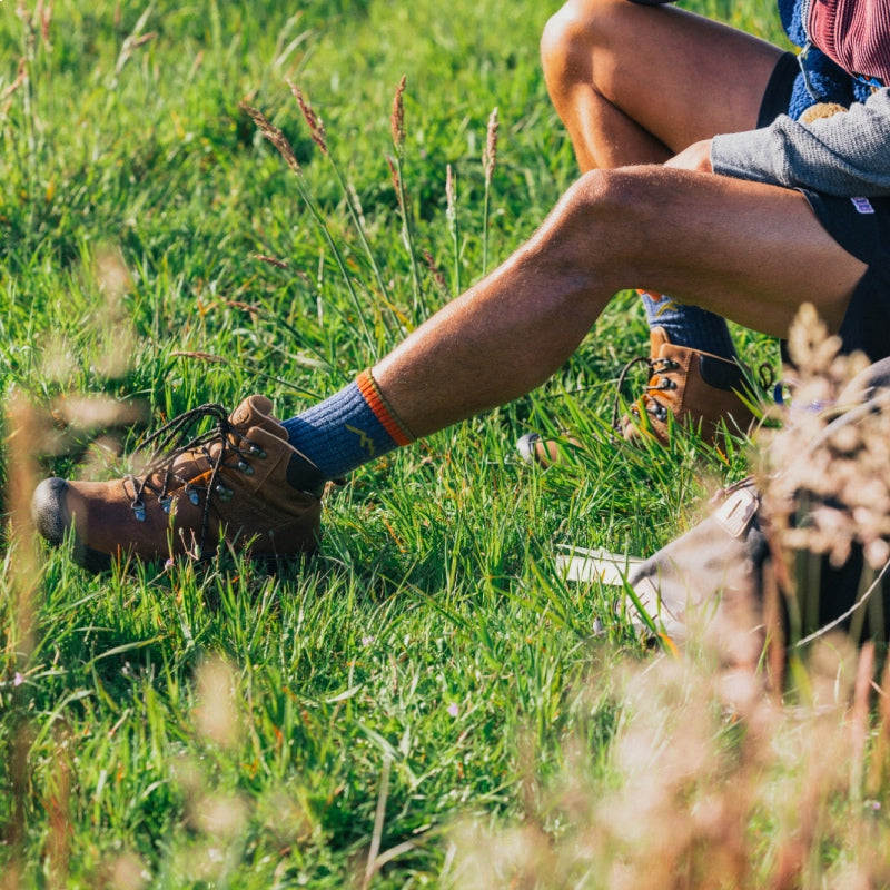 Hiker in a grassy field wearing hiking boots and the 1466 hiker micro crew hiking socks