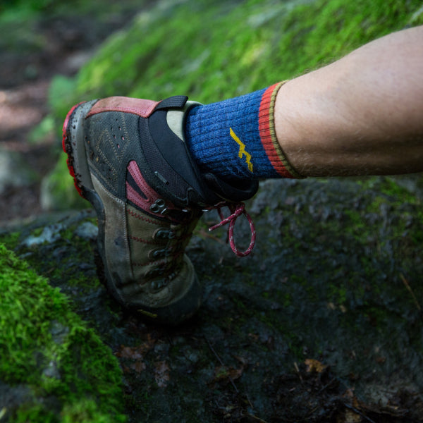 Boot and sock-clad foot heading up a hiking trail