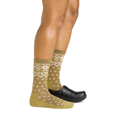 Side studio shot of model wearing women's shetland crew lightweight lifestyle sock in honey with black show on left foot