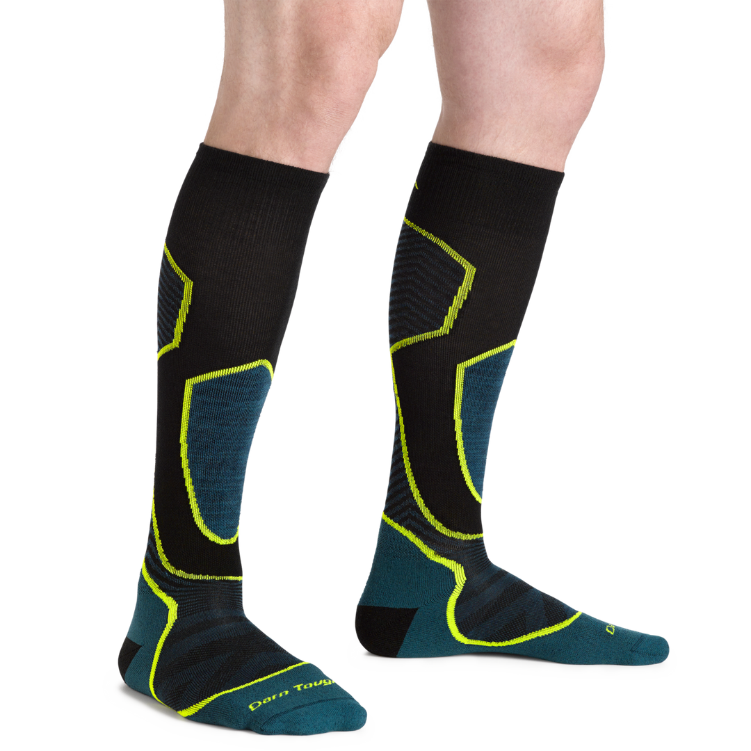 Model wearing Men's Outer Limit Over-the-Calf Lightweight Ski and Snowboard Sock in blue, black and green