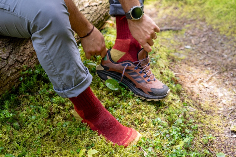 Shop Limited Edition socks - feet putting on shoes over red hiking socks