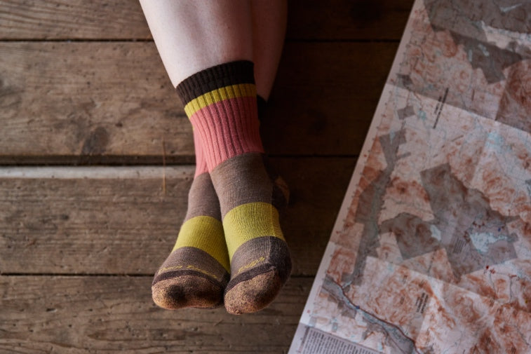 Shop New Socks - feet wearing pink, yellow, and brown socks