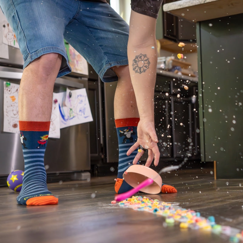 Sock-clad feet and outreached hand too late to stop the spilled bowl of cereal