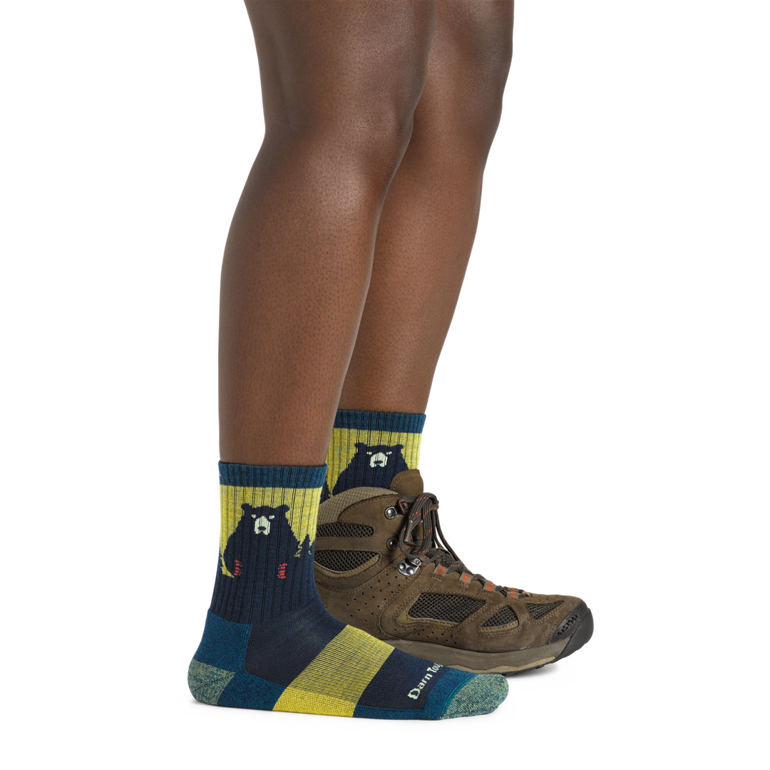 Model wearing the Women's Bear Town Micro Crew Hiking Sock in Dark Teal with a brown hiking boot on one foot
