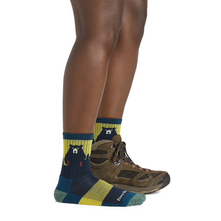 Model wearing the Women's Bear Town Micro Crew Hiking Sock in Dark Teal with a brown hiking boot on one foot