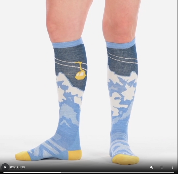 Video of model wearing yeti over the calf snow socks in midnight, walking around to show all angles of the socks.