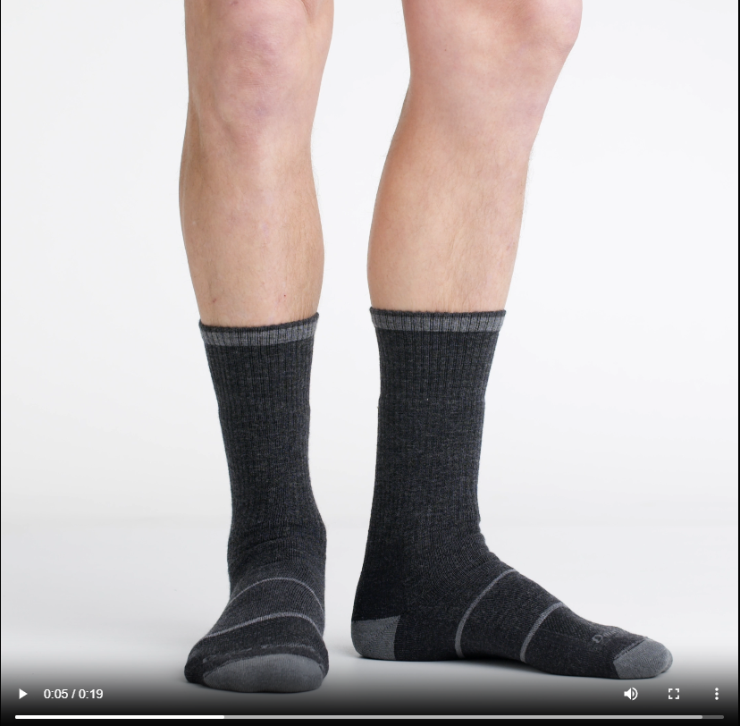 Video of model wearing william jarvis boot socks in gravel, rotating around to show the fit of the socks.
