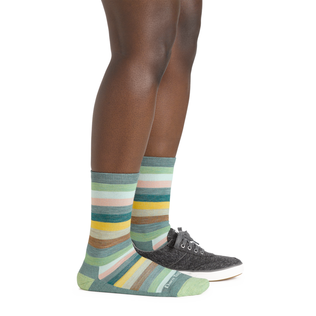 Model wearing the Women's Mystic Stripe Crew Lightweight Lifestyle Sock in seafoam with one casual canvas shoe
