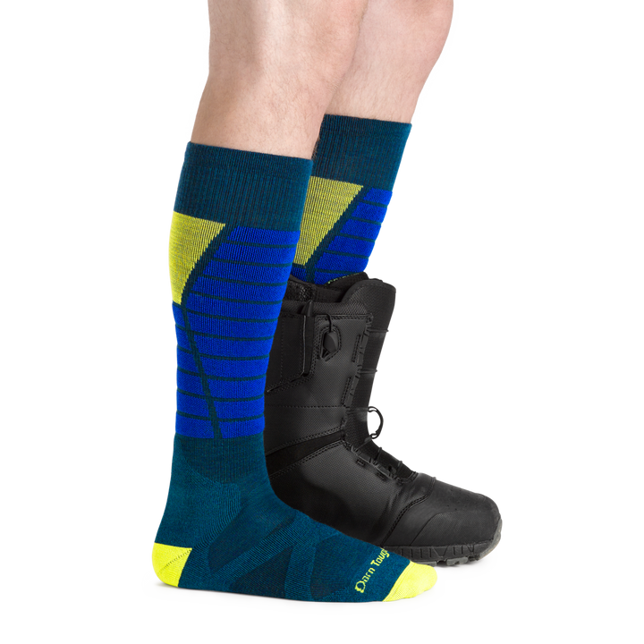 Men's Function X Over-the-Calf Ski and Snowboard Sock in blue and green with a snowboard boot on one foot