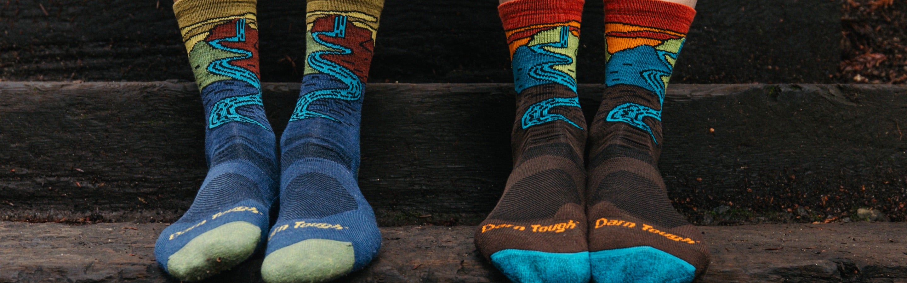 Two pairs of feet in matching Darn Tough socks with a waterfall design