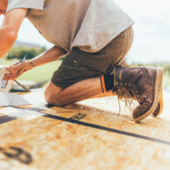 Close up shot of model wearing Steely micro crew socks and work boots, while building a house.