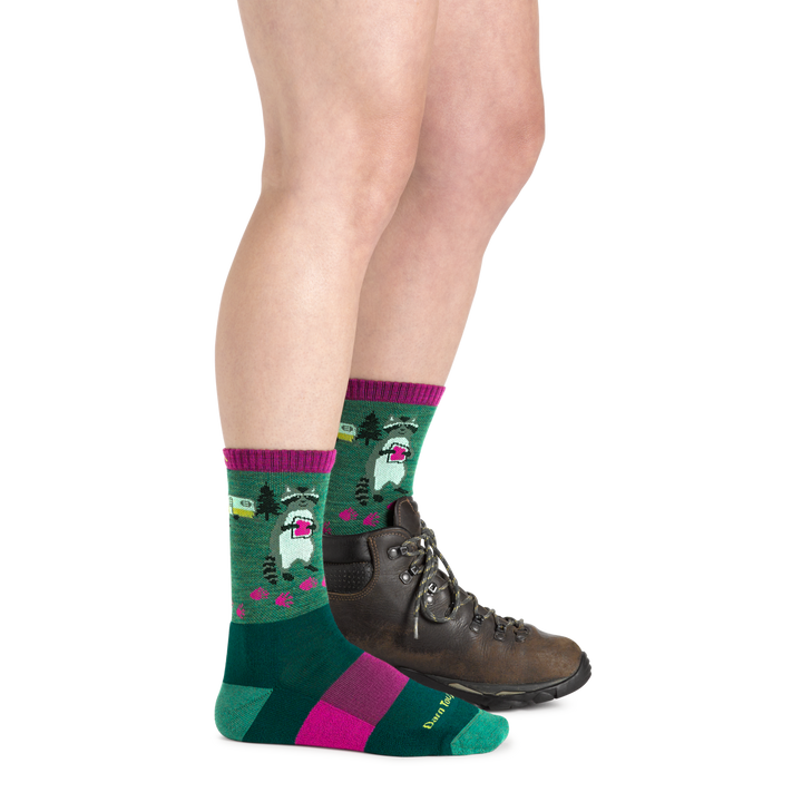 Woman wearing the Women's Critter Club Micro Crew Hiking Sock featuring a raccoon eating a jelly sandwich from a camper