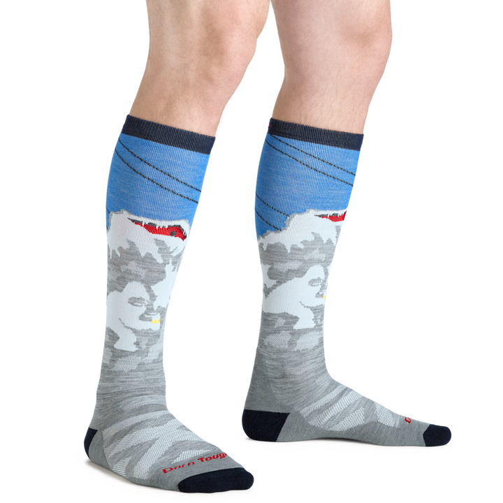 Man wearing the Men's Heady Yeti Over-the-Calf Ski and Snowboard socks with white yeti design on calf showing