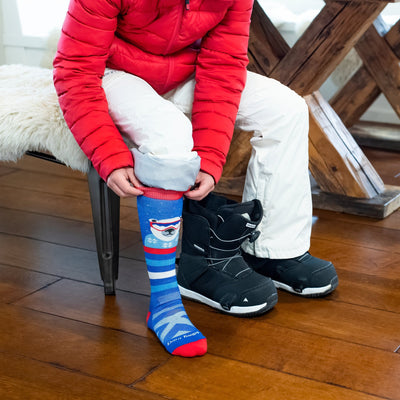 Close up shot of model siting on an indoor bench putting on the kids&