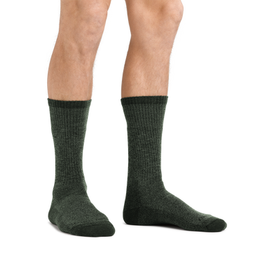 Man standing barefoot wearing  Nomad Boot Midweight Hiking Socks in Moss