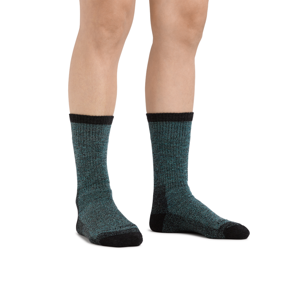 Image of a woman's legs on a white background wearing Image of a woman's feet on a wooden porch in the woods, hiking boots in the background, wearing Women's Nomad Boot Midweight Hiking Socks in Aqua