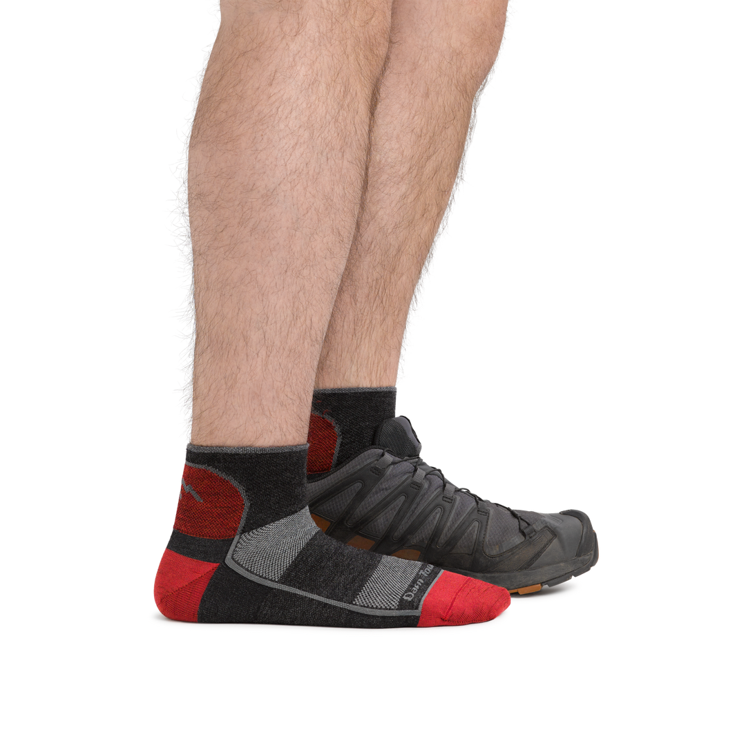 Man standing with front foot barefoot and back foot with an athletic sneaker, wearing 1715 Quarter Lightweight Athletic Sock in color Team DTV, showing the quarter sock height hits just above the ankle.