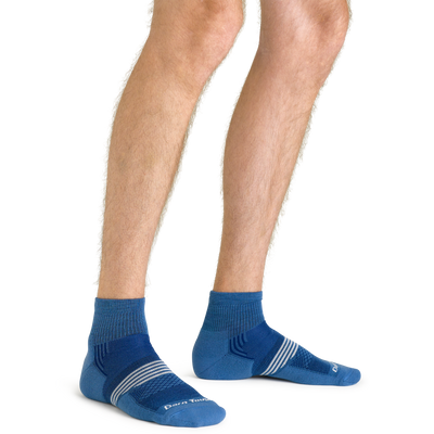 Close up studio shot of model wearing men's element quarter lightweight atheltic sock in cobalt blue